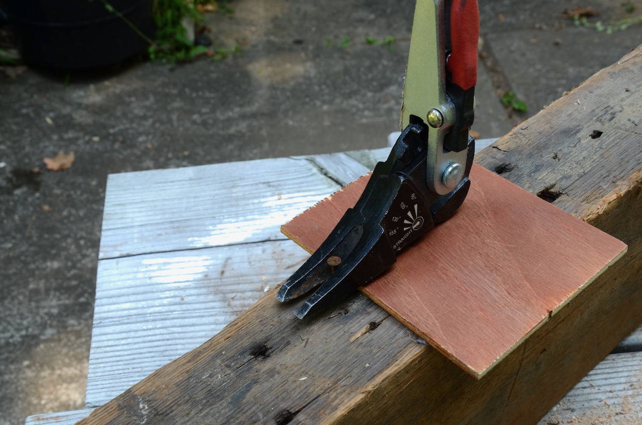 A thin piece of plywood placed under an adjustable nail extractor.