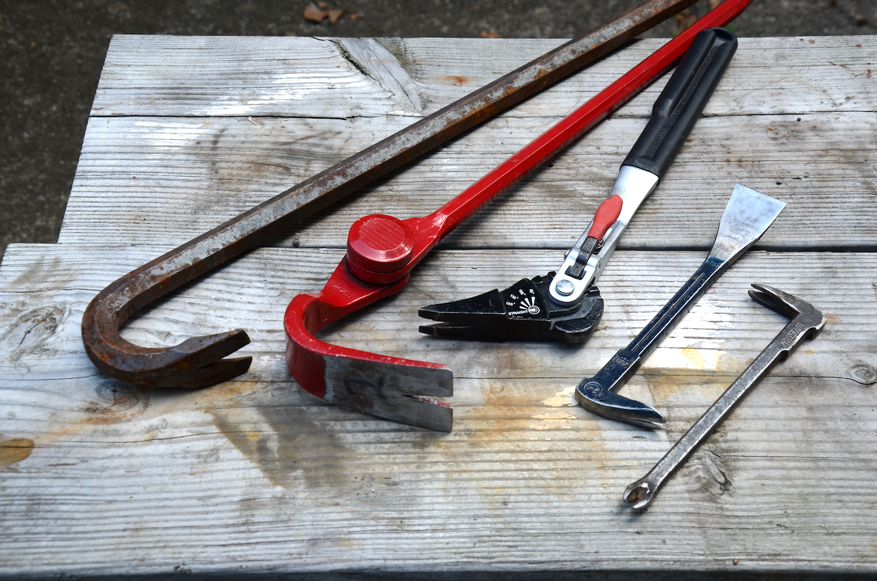 A photo of two pairs of cat paws, two adjust able pry bars, and a traditional pry bar.