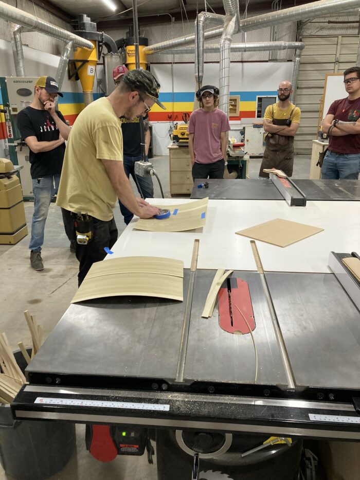 Philip Morley, the lead intructor at Austin School of Furniture, shows students how to seam veneer to create lumber core panels.