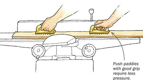 Using push pads to feed a piece of lumber into a jointer